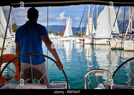 Un uomo aziona un yacht Foto Stock