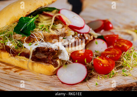 Sandwich con carni fresche insalate e verdure pomodori ciliegia, Rafano, cipolle, formaggio, salsa Foto Stock