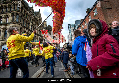 Il Drago annuale sfilata per le strade di Manchester, Regno Unito, per celebrare il nuovo anno cinese del maiale. Migliaia di persone rivestite le strade per Foto Stock