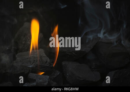 Close up di un cuore-shaped​ fiamma ardente del carbone sul barbecue Foto Stock