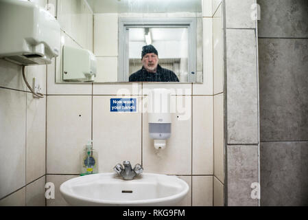 Uomo Barbuto in specchio, lavarsi subito le mani segno, wc pubblico,dell'essiccatore della mano, dosatore per sapone liquido, Foto Stock