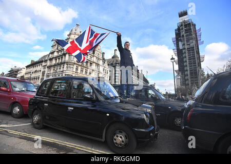 I tassisti bloccano la strada durante una manifestazione di protesta al di fuori della sede del parlamento di Londra nella ultima fase di proteste in corso contro TFL e autorità locali che stanno limitando il loro accesso a parti di Londra. Foto Stock