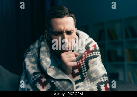 Uomo bello tosse pur avendo influenza a casa Foto Stock