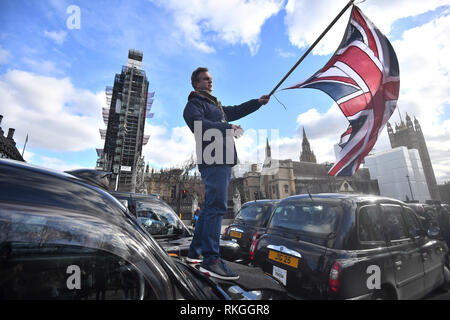 I tassisti bloccano la strada durante una manifestazione di protesta al di fuori della sede del parlamento di Londra nella ultima fase di proteste in corso contro TFL e autorità locali che stanno limitando il loro accesso a parti di Londra. Foto Stock