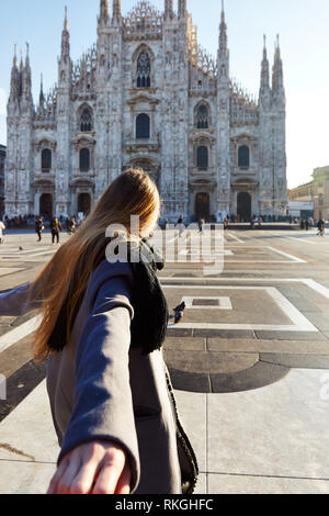 Travel Tourist girl tirando la mano sulla parte anteriore del Duomo Milano Italia durante il giorno Foto Stock