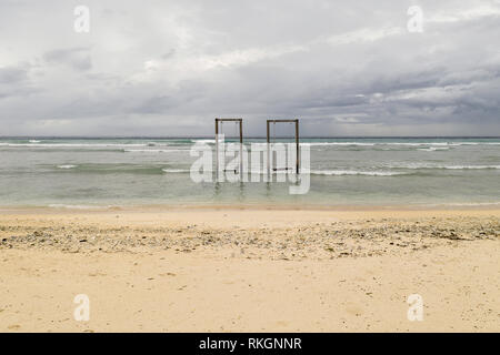 Gili Trawangan, Indonesia - 22 Gennaio 2019: due altalene in legno nell'acqua del mare sullo sfondo con cielo nuvoloso. Ci sono onde sul mare surfac Foto Stock