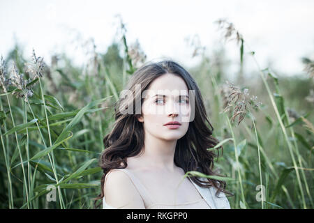 Ragazza solitaria ritratto. La molla donna camminare da solo all'aperto su erba verde sullo sfondo Foto Stock