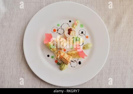 Frittelle con prosciutto e formaggio, decorata con insalata su uno sfondo luminoso. La cucina russa tradizionale cucina molecolare Foto Stock