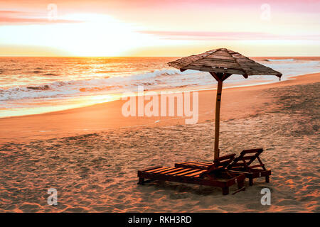 Tramonto sull'oceano pacifico del Perù a punta rocas spiaggia con sdraio e ombrellone, nessun popolo. playa punta rocas Foto Stock