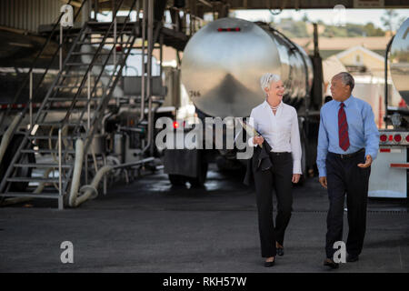 Due maturi i dirigenti dell'olio discutere la futura direzione della loro azienda mentre al carrello olio cantiere. Foto Stock