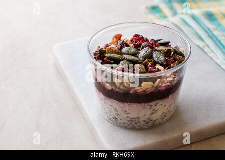 Sana budino di Chia con i semi di zucca / Acai la ciotola in una tazza di plastica. Dessert organico. Foto Stock