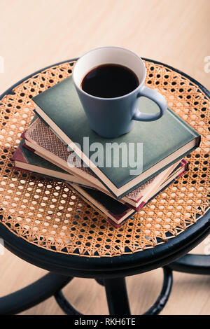 Un paio di libri con tazza di caffè sulla sedia Foto Stock