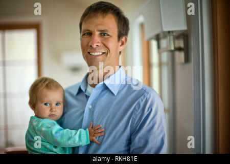 Ritratto di un padre sorridente tenendo la sua bimba. Foto Stock