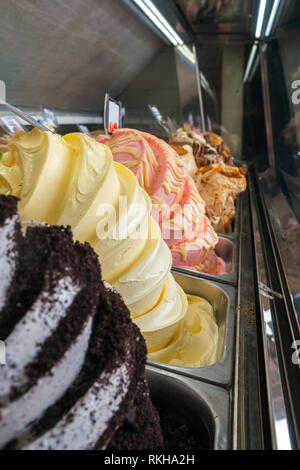 Visualizzazione di un assortimento di gelati in vasche di metallo in un negozio o gelateria close-up Foto Stock