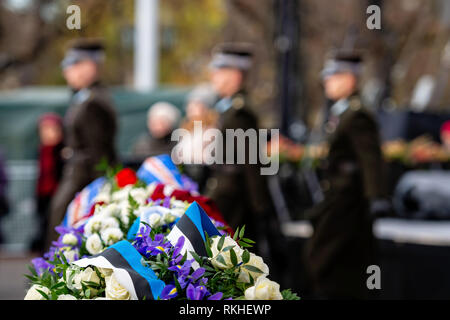 Abstract background sul tema militare. Bouquet di fiori con bandiera estone colori nastro. Un cambiamento del soldato di guardia di sfondo - Immagine Foto Stock