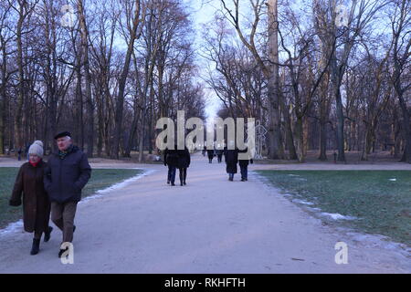 Le coppie a piedi attraverso il parco in un freddo giorno Foto Stock