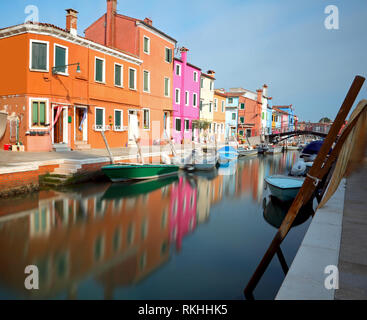 Burano è un'isola nel nord Italia vicino a Venezia con le sue caratteristiche case colorate che si riflettono sui canali navigabili lavato mediante l'INHA Foto Stock