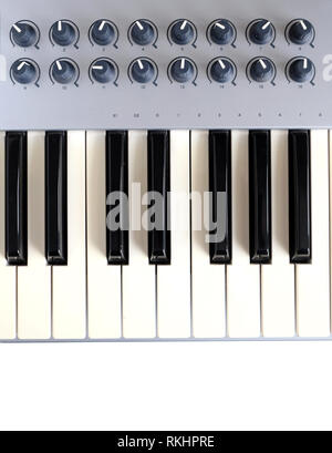 Frammento di sintetizzatore elettronico tastiera con molti pulsanti di controllo isolato su sfondo bianco top view closeup Foto Stock