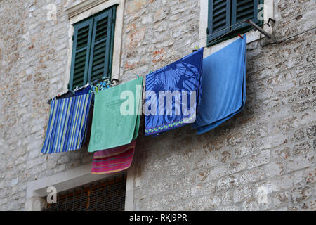 La biancheria lavata viene essiccato sulla parete della casa Foto Stock