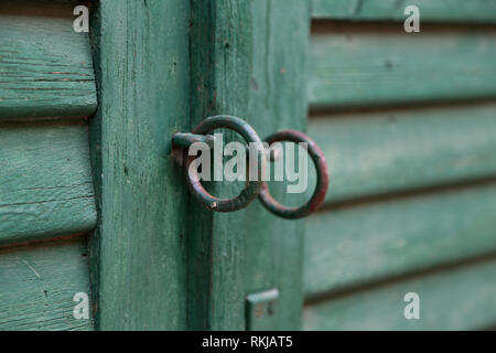 Anelli metallici sul gate / porta di legno con cancello forgiato anello maniglia Foto Stock