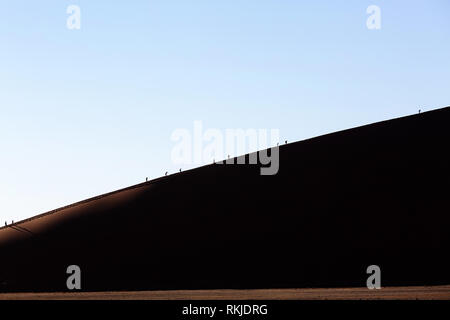 I turisti la scalata al Sossusvlei dune in Namibia Foto Stock