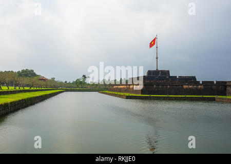 Un flag tower e il Ngoai Kim Thuy fossato nella città imperiale di Hue, Vietnam Foto Stock