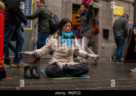 Londra, UK, 10 febbraio, 2019. Donna cinese visto che protestavano contro il governo cinese reprimere gente pratica l antica tradizione del Falun Gong durante la celebrazione del Capodanno cinese a China Town, Soho, Londra, Regno Unito. Alamy/Harishkumar Shah Foto Stock