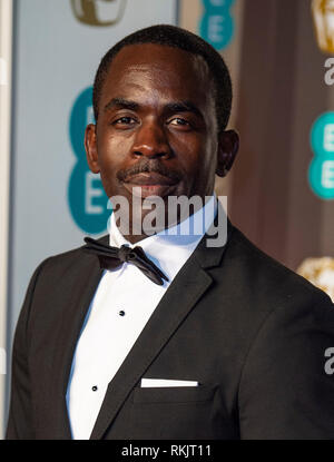 Jimmy Akingbola assiste l'EE British Academy Film Awards alla Royal Albert Hall di Londra. Foto Stock