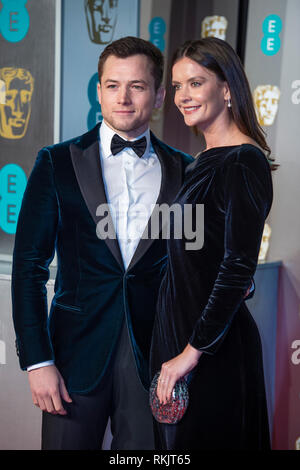 Taron Egerton e valutazione assiste l'EE British Academy Film Awards alla Royal Albert Hall di Londra. Foto Stock