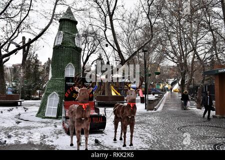 Ankara, Turchia. Xvii gen, 2019. Due donne a piedi passato un albero di Natale con il cervo in legno e una mazza nel famoso Parco di Kugulu durante una giornata nevosa. Credito: Altan Gocher | in tutto il mondo di utilizzo/dpa/Alamy Live News Foto Stock