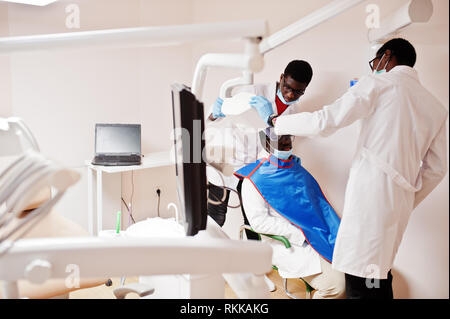 African American medici di sesso maschile in uniforme professionale tenuto a raggi x del paziente. Foto Stock