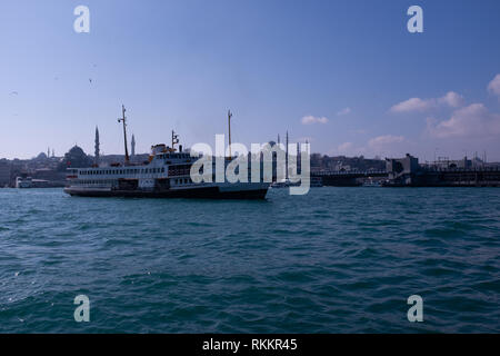 Un traghetto a Eminönü quartiere di Istanbul, Turchia. Con Süleymaniye e La Yeni moschee. Foto Stock