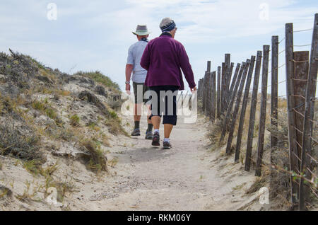 Coppia matura camminare al fianco di costiera linea di recinzione. Turisti senior di esplorare i sentieri lungo la penisola sgrossato Valdes, costa Argentina. Foto Stock
