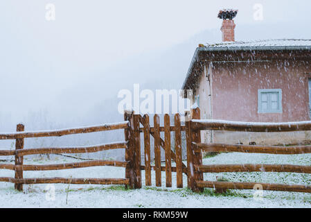 Vecchio edificio e recinzione in legno in inverno Foto Stock