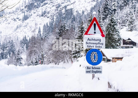 Il traffico della catena di segno, Bei Schnee und Eisglätte avvertimento, servizi invernali, catena da neve obbligo. Coperta di neve su strada e alberi. Austria, Europa Foto Stock