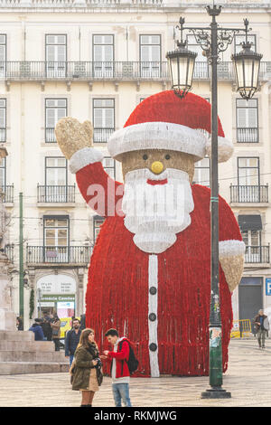 Lisbona, Portogallo - 01/03/19: vista anteriore del gigante Santa statua nel mezzo di Baixa Chiado, Lisbona, Portogallo. Palle rosse decorazioni natalizie. Foto Stock