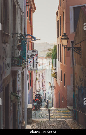 Lisbona, Portogallo - 01/03/19: Bella e tipica stradina nel Bairro Alto, moto su di una collina al tramonto, golden giallo luce scale e street l Foto Stock