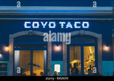 Lisbona, Portogallo - 01/03/19: Coyo Taco shop anteriore di colore blu, esterna shot calde luci gialle di persone all'interno del ristorante vicino a principe real. Foto Stock