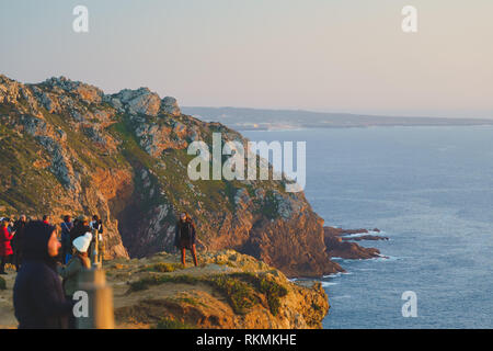 Sintra, Portogallo - 01/05/19: persone in piedi sul bordo dell'Europa tramonto, Cape roca. Europeo occidentale. Persone appeso su una rupe enorme Foto Stock