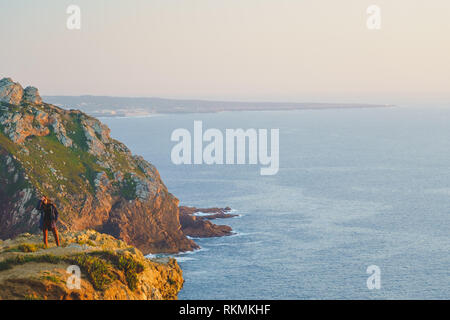 Sintra, Portogallo - 01/05/19: persone in piedi sul bordo dell'Europa tramonto, Cape roca. Europeo occidentale. Persone appeso su una rupe enorme Foto Stock