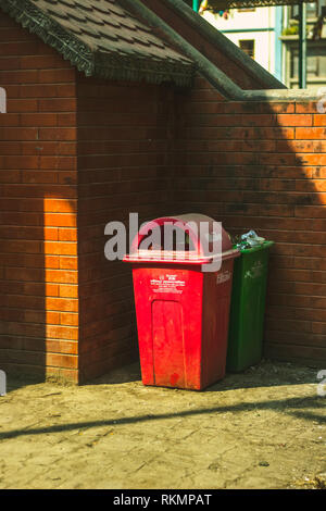 Il rosso e il verde pattumiere accanto a una parete Gabinetto Foto Stock