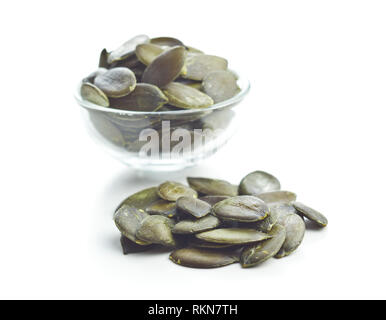Sbucciate i semi di zucca in un recipiente isolato su sfondo bianco. Foto Stock