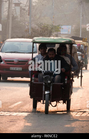 Uomo alla guida di auto elettriche rickshaw con passeggeri di Amritsar, India Foto Stock