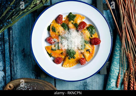 Paste Mezzalune fatte a mano farcite con melanzane, e servite su un piatto bianco rotondo Foto Stock