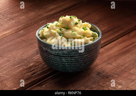 Pomme purea, una foto di una tazza di purea di patate con erbe al buio su un sfondo rustico con spazio di copia Foto Stock