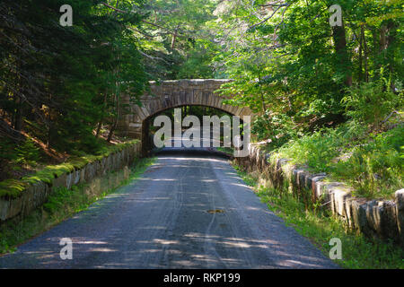 Il ponte di pietra che attraversano una strada carrabile nel Parco Nazionale di Acadia, Maine, Stati Uniti d'America. Il carrello le strade sono aperte solo ai cavalli e biciclette. Foto Stock