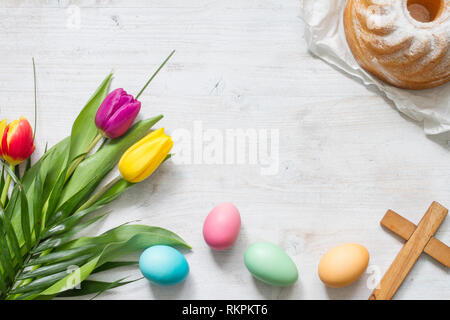 Pasqua Primavera colorati tulipani con palm croce torta e uova decorazione su legno bianco sfondo naturale Foto Stock