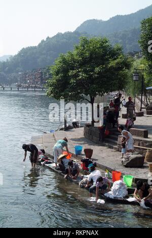 La gente del posto il lavaggio di biancheria e abiti in Tou Jiang River a Fenghuang. Significato 'Phoenix' in cinese, Fenghuang è stato chiamato dopo il mitico uccello di imm Foto Stock