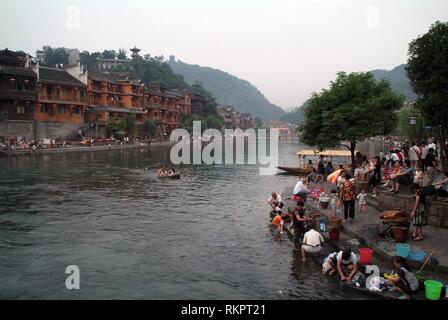 La gente del posto il lavaggio di indumenti e biancheria in Tou Jiang River a Fenghuang. Significato 'Phoenix' in cinese, Fenghuang è stato chiamato dopo il mitico uccello di immort Foto Stock