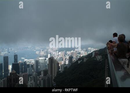 Lentamente la nebbia che copre la città di Hong Kong come visto dal piano superiore del picco. Un multi-luogo di divertimento costruito nella forma di un gigante di wok, il Foto Stock